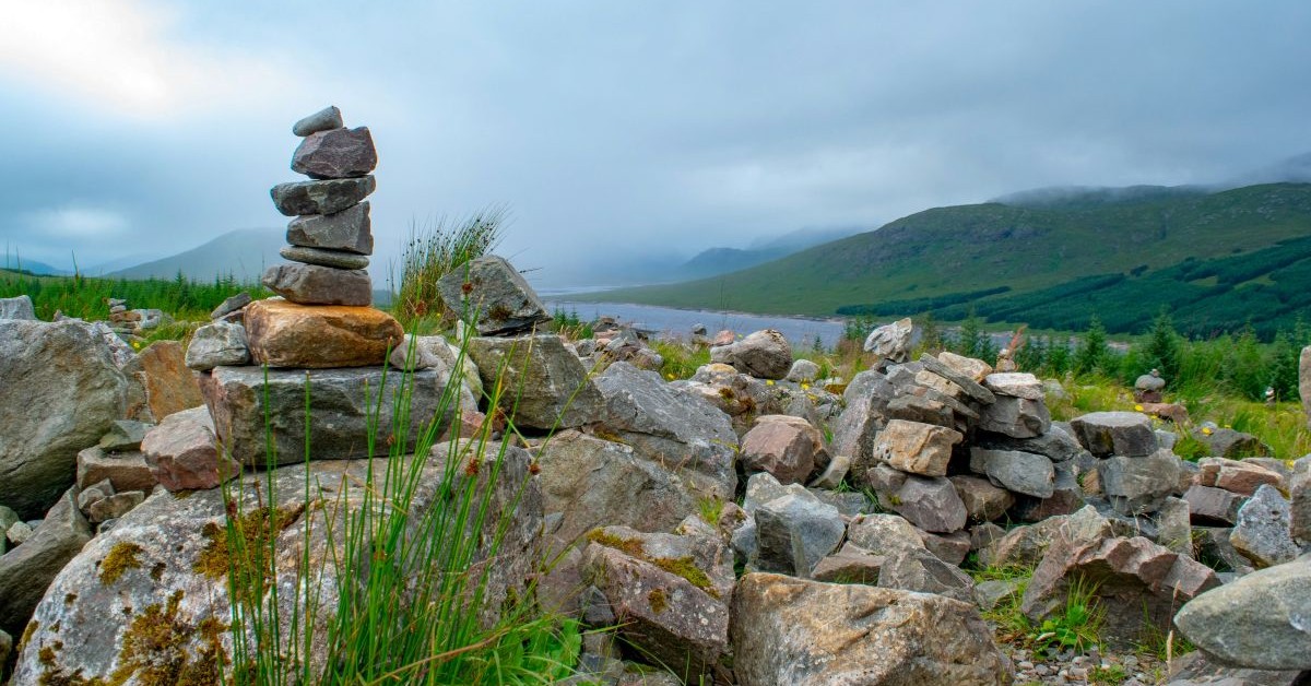 clear rock cairn in front of foggy landscape